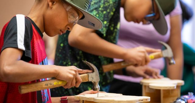 Two participants working with wood and hammers during the 2024 Summer Reading Program Build It Workshop at our Irvington Branch.